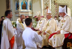 Novi škof med posvečenjem, zadaj msgr. Andrej Glavan (v sredini), msgr. Jean-Marie Speich (na levi) ter msgr. Jože Marketz (na desni).