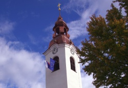 S prenovljenega zvonika plapolata slovenska in evropska zastava.