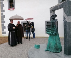 P. Tomaž Hočevar (prvi z leve) občuduje kip Frančiškan z rastočo knjigo.