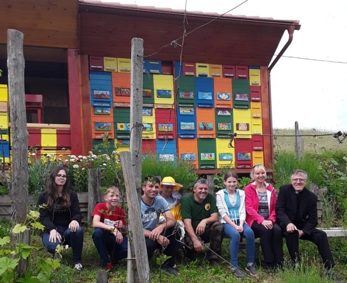 Ob čebelnjaku z nekaj učenci, mentorico Tanjo Dvornik in župnikom Slavkom Kimovcem iz Trebnjega (Foto: arhiv Petra Flisa)