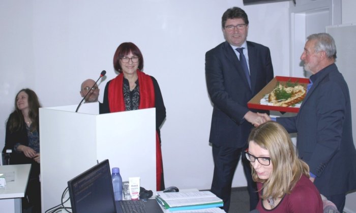 Županu (v sredini) so predali pleteno srce, o katerega široki simboliki je govorila Ivanka Počkar (za govorniškim pultom). Desno Marijan Žibert, ki je bil predsedujoči v prvem delu včerajšnje seje. (Foto: M. L.)