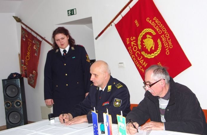 Pogodbo za nov gasilski avto sta podpisala Robert Janežič in Marjan Pušnik. Na levi gasilka Katja Banič.