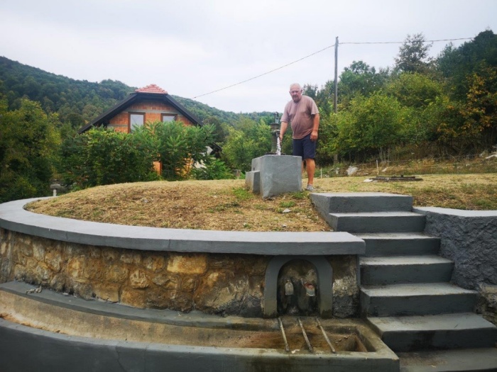 Ivan Žalec ob obnovljenem vodnjaku in črpalki, ki je še v uporabi. (Foto: M. G.)