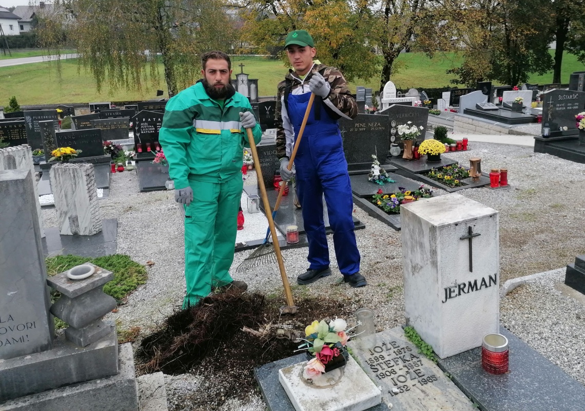 Pred 1. novembrom so imeli veliko dela na pokopališčih s čiščenjem zeli in z urejanjem tudi komunalni delavci. Na sliki dva izmed njih na šmihelskem pokopališču. (Foto: L. M.)